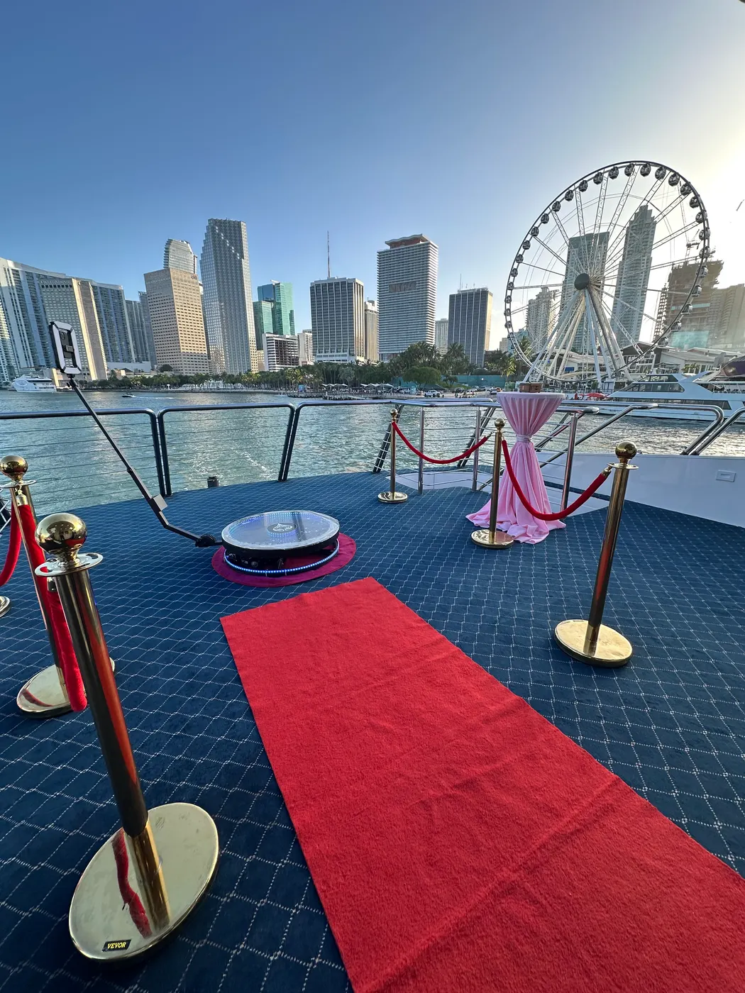 360 photo booth on a red carpet with the Miami skyline behind it