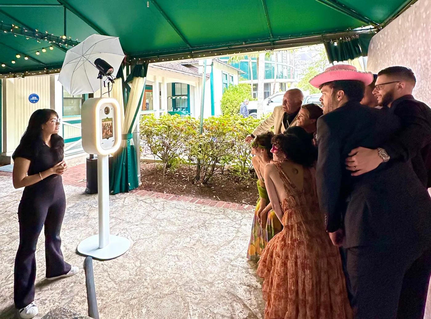 Guests at an outdoor garden party photo booth in South Florida
